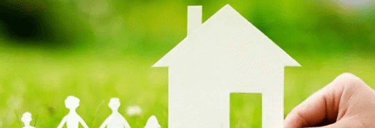 cardboard house with family outside