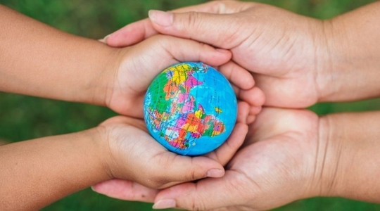 people holding small globe in hands