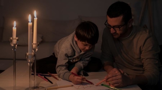father and son drawing by candle light