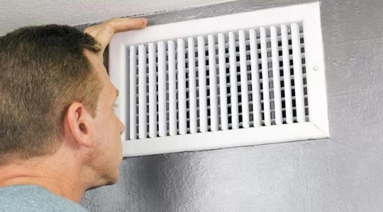 man looking into vent