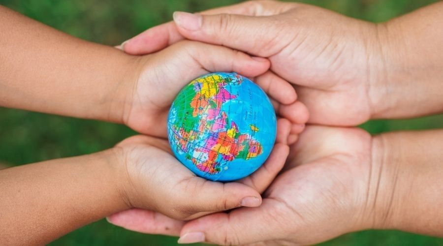 people holding small globe in hands